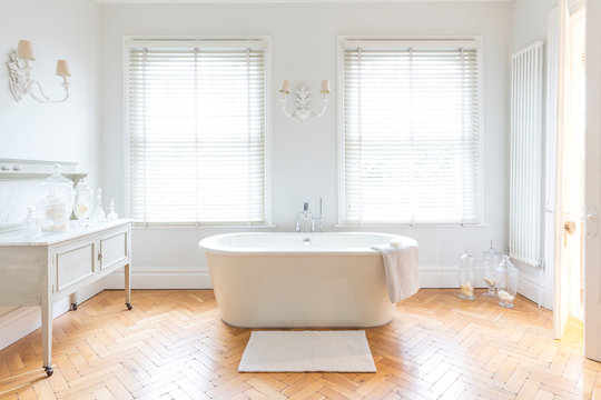 White, luxury home showcase bathroom soaking tub parquet hardwood floor