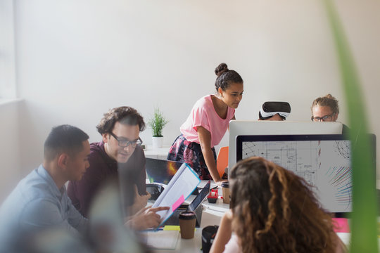 Computer programmers and designers working in open plan office