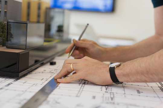 Close up architect drafting blueprint with ruler and pencil