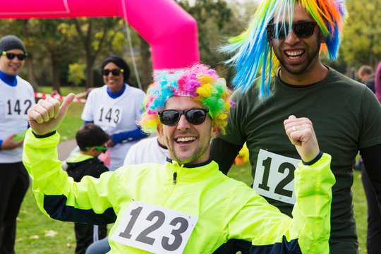 Portrait enthusiastic male runners wearing wigs at charity run