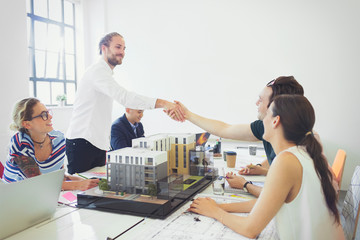 Architects handshaking in conference room meeting