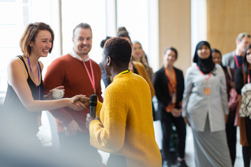 Businesswoman shaking hands with speaker at conference