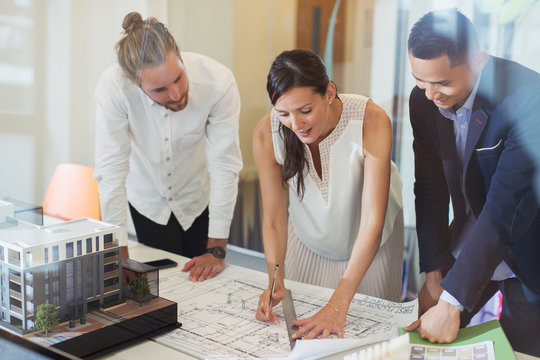 Architects drafting blueprint in office