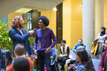 Audience watching speaker and man talking with microphone