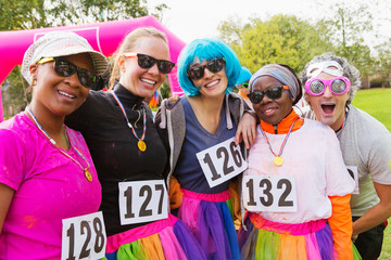 Portrait smiling, playful runner friends at charity run in park