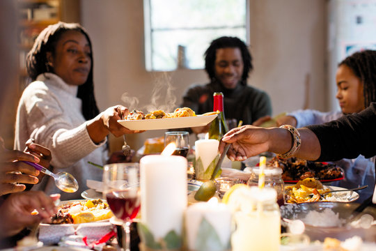 Woman passing food at Christmas dinner