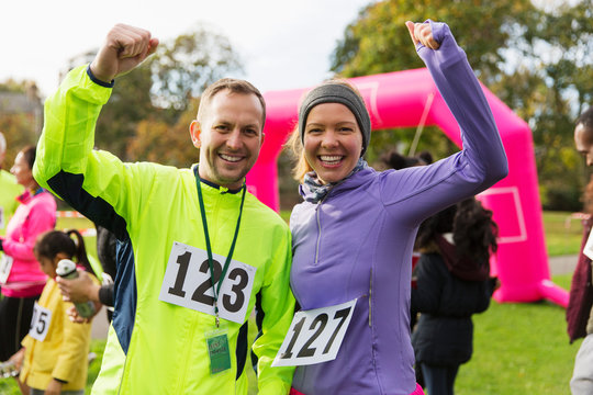 Enthusiastic runner couple cheering at charity run in park