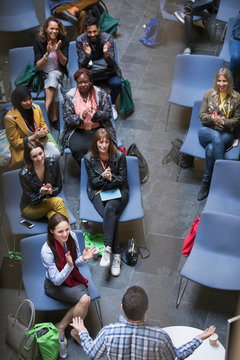 Conference audience clapping for male speaker