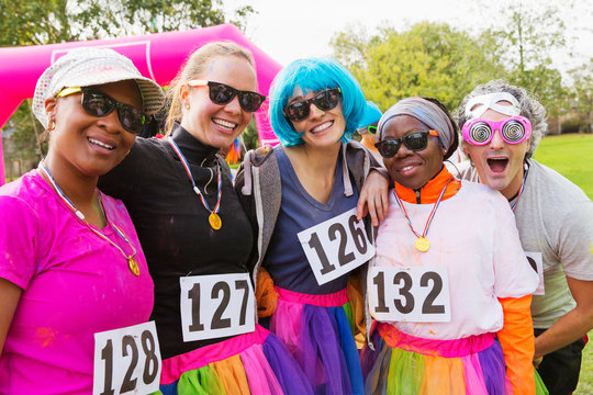 Portrait smiling, playful runner friends at charity run in park
