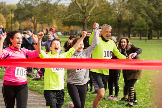 Enthusiastic family running, nearing charity run finish line