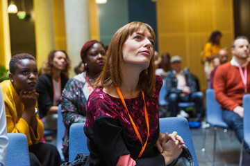Attentive, focused businesswoman listening in conference audience