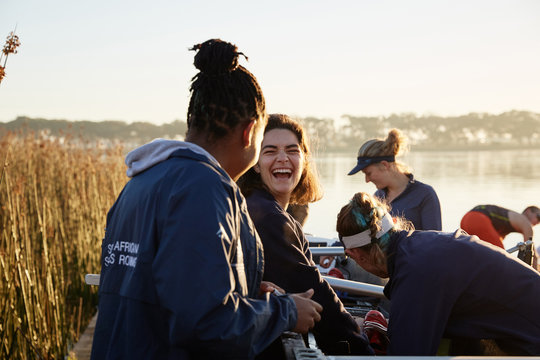 Female rowers laughing at lakeside