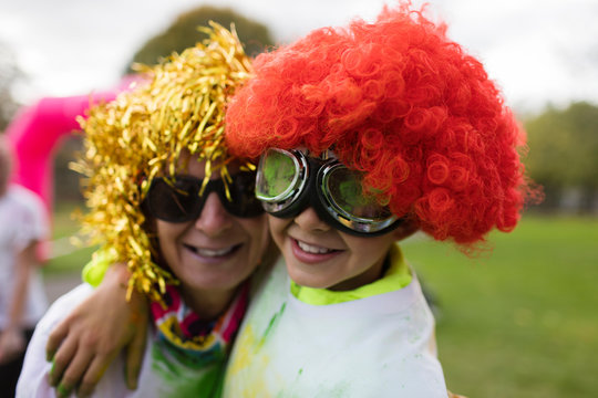 Portrait playful mother and son wearing wigs and goggles