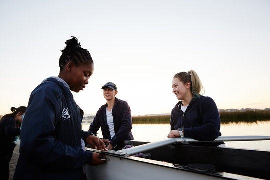 Female rowers preparing scull