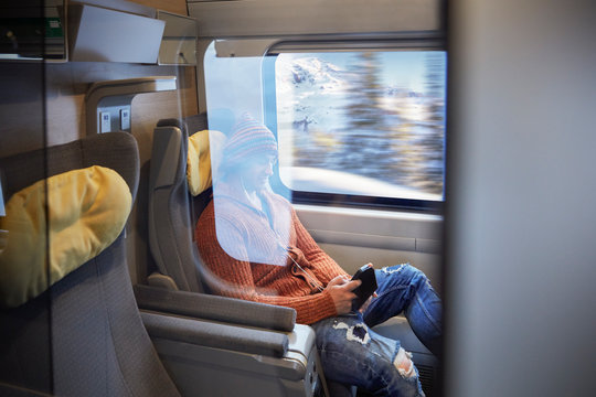 Young man using smart phone on passenger train