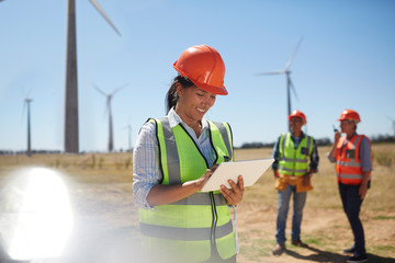 Smiling engineer using digital tablet at sunny power plant