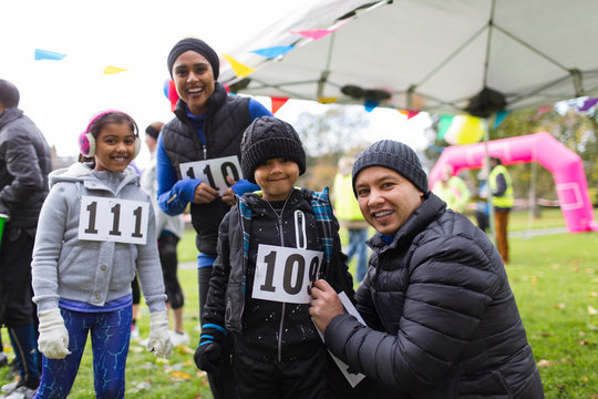 Portrait smiling family preparing for charity run in park
