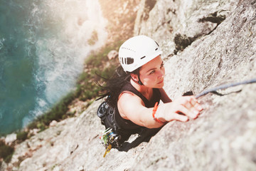 Focused, determined female rock climber scaling rock