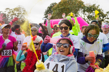 Portrait playful runners with holi powder at charity run in park