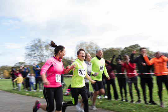 Enthusiastic family runners running at charity run in park