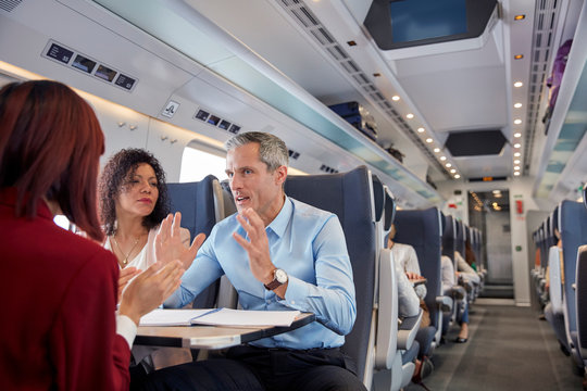 Business people working, talking on passenger train