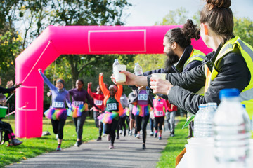 Volunteers water ready for charity run runners crossing finish line