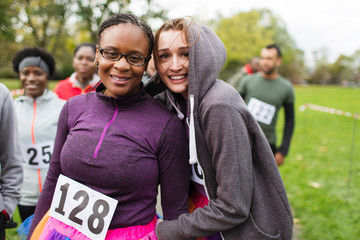 Portrait smiling, confident female runners at charity run in park