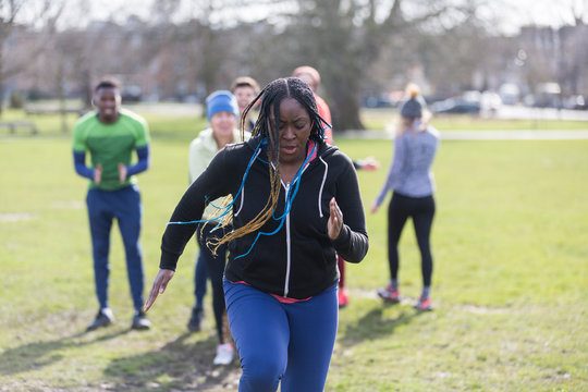 Focused woman doing speed ladder drill in park