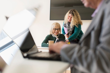 Businesswomen using digital tablet in conference room meeting
