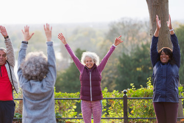 Confident, energetic active seniors practicing yoga in park