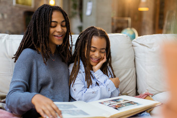 Smiling sisters looking at photo album