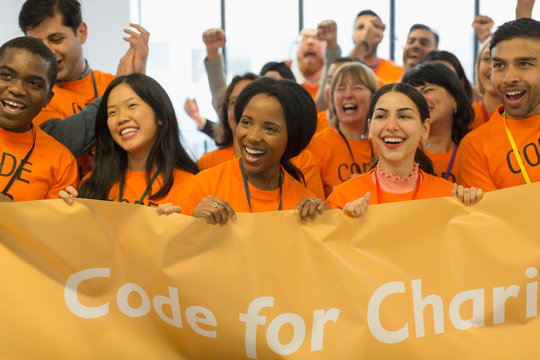 Happy hackers with banner coding for charity at hackathon