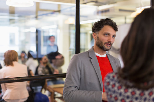 Attentive businessman listening to colleague in office