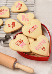 Valentines Day Concept: Heart shaped sugar cookies in a heart shaped box with cooling rack and rolling pin.
