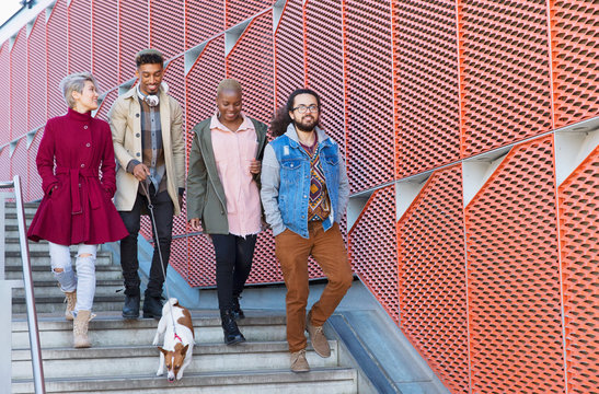 Young friends walking down down urban, modern stairs