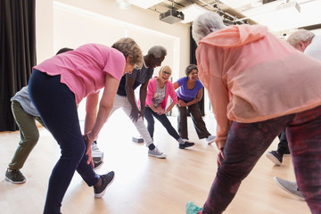 Active seniors stretching legs in exercise class