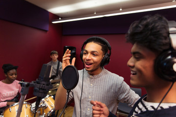 Teenage musicians recording music in sound booth