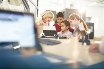 Teacher and students using laptop