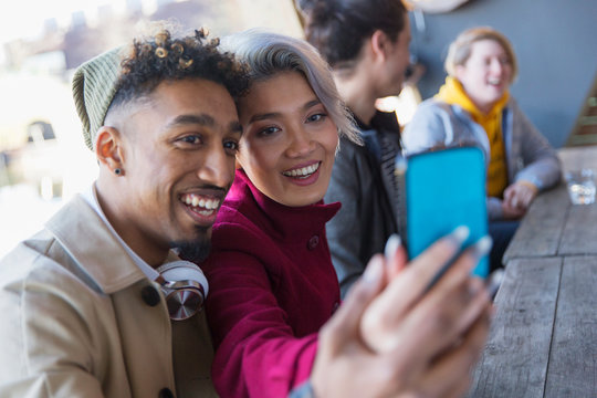 Smiling young couple taking selfie in camera phone