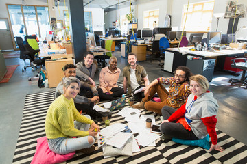 Portrait confident creative business team meeting, brainstorming in circle on office floor