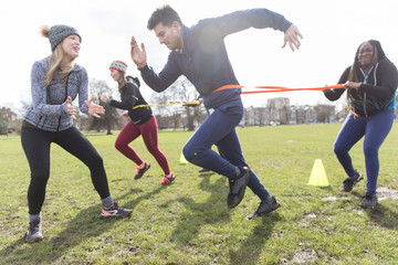 People exercising, doing team building exercise in sunny park