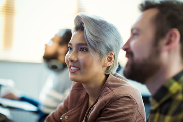 Smiling creative businesswoman listening in meeting
