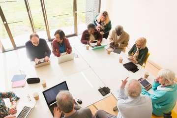 Senior business people using laptops digital tablets in conference room meeting