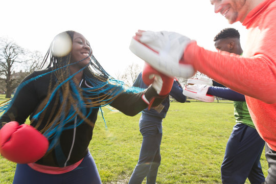 Smiling woman boxing in park