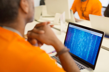 Hacker at laptop coding for charity at hackathon
