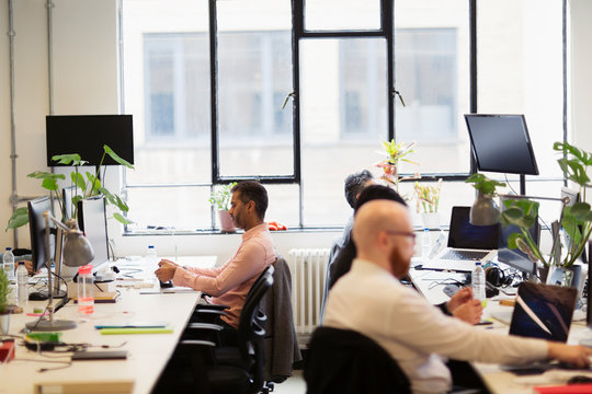 Businessmen working in open plan office