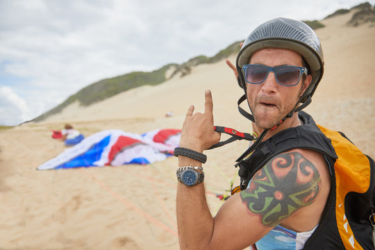Portrait confident, carefree male paraglider on beach