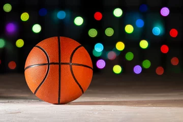 Fotobehang Basketball on a texture surface with defocus colourful lights on the background. © oasisamuel