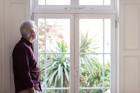 Thoughtful Senior Man Looking Out Window