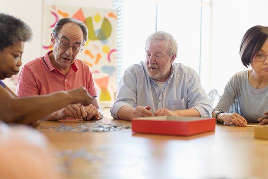 Senior friends playing games at table in community center